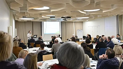 Eine Frau hält einen Vortrag vor vielen Menschen